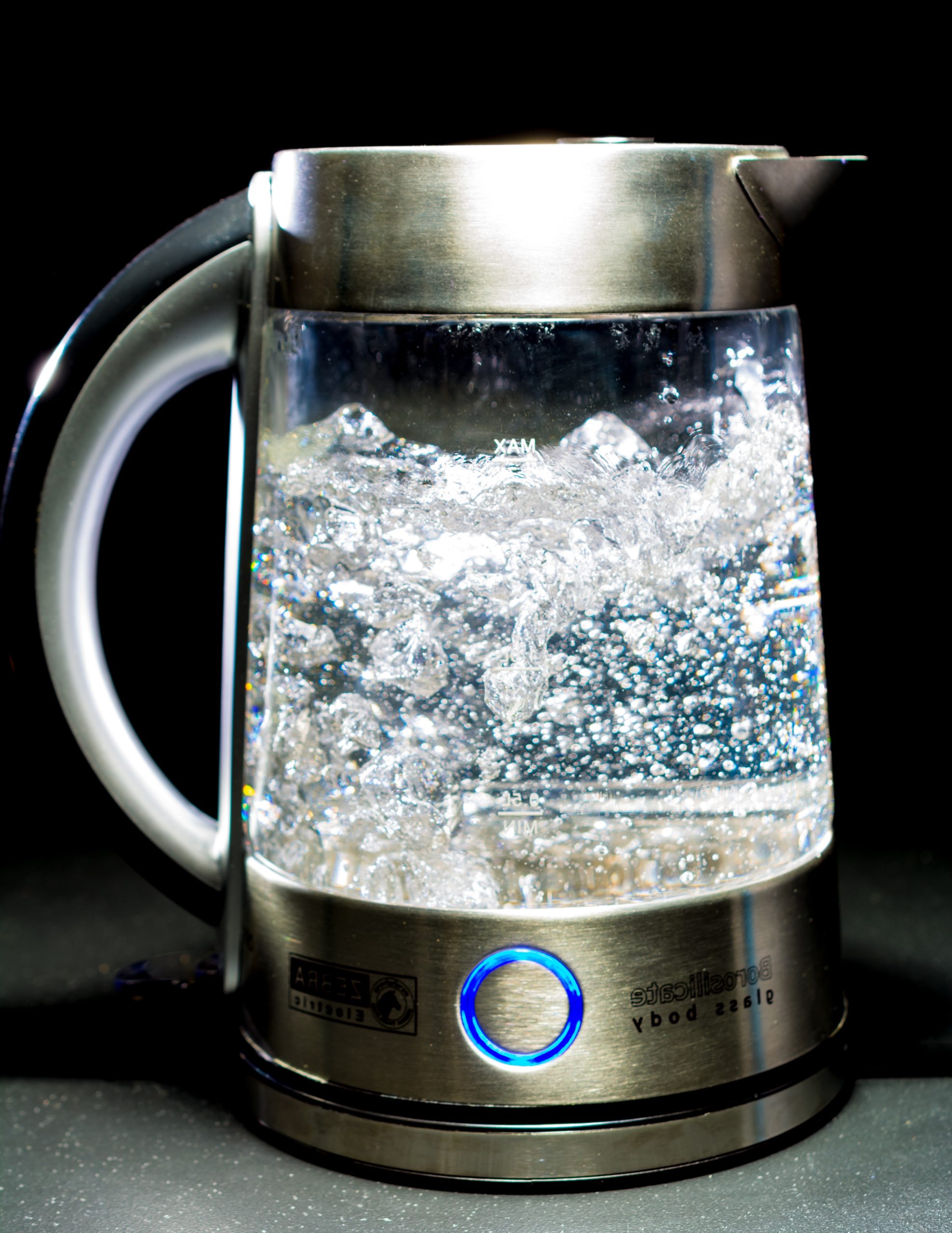 Sauberer Glas-Wasserkocher mit sprudelndes Wasser