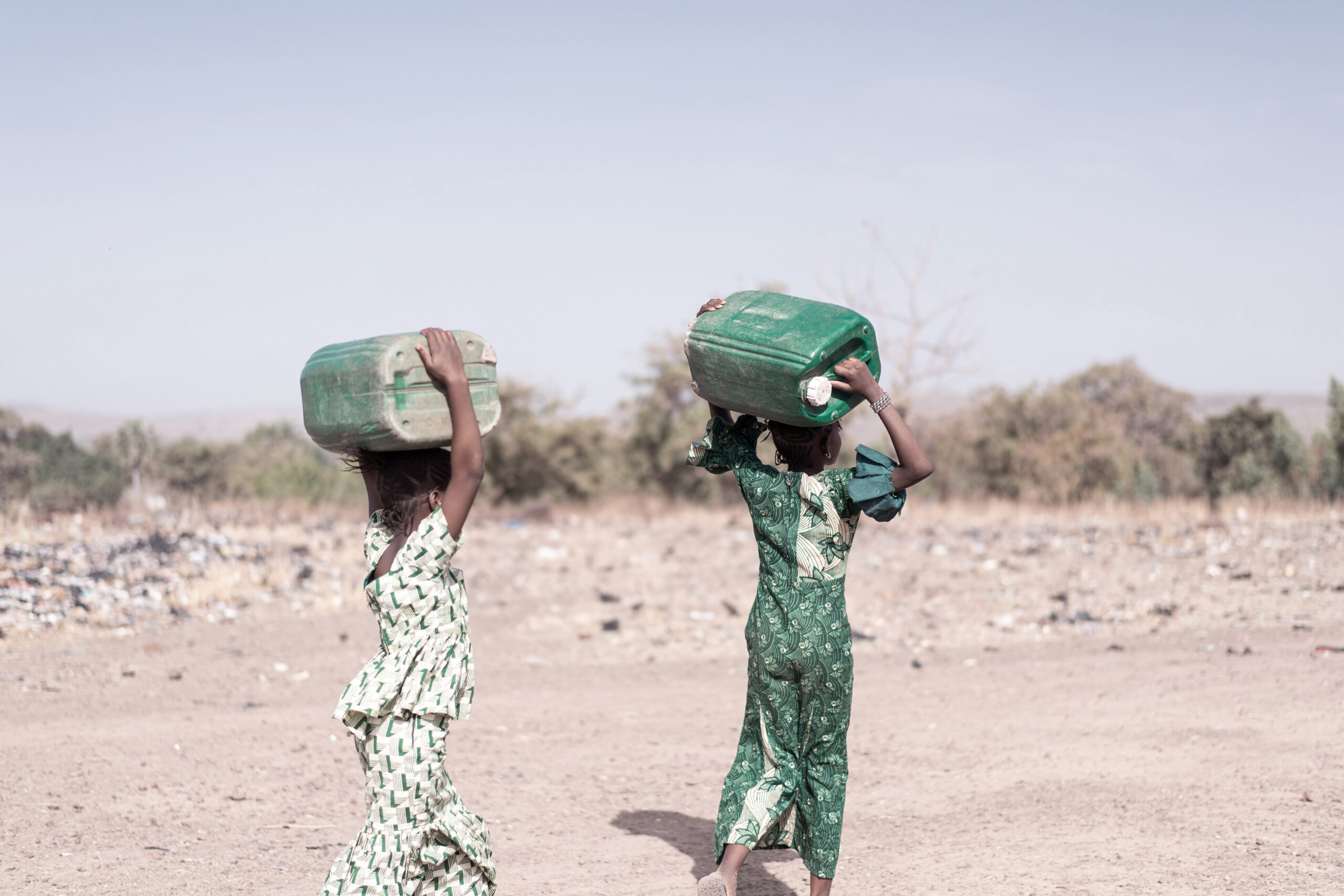 Tiny Native African Young Woman Gathering Pure Water in a typical village